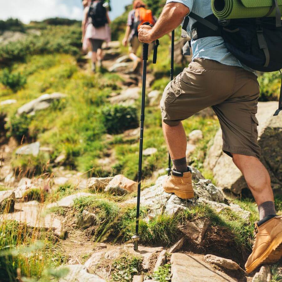 Hiker with hiking sticks and backpack hiking on a beautiful trail