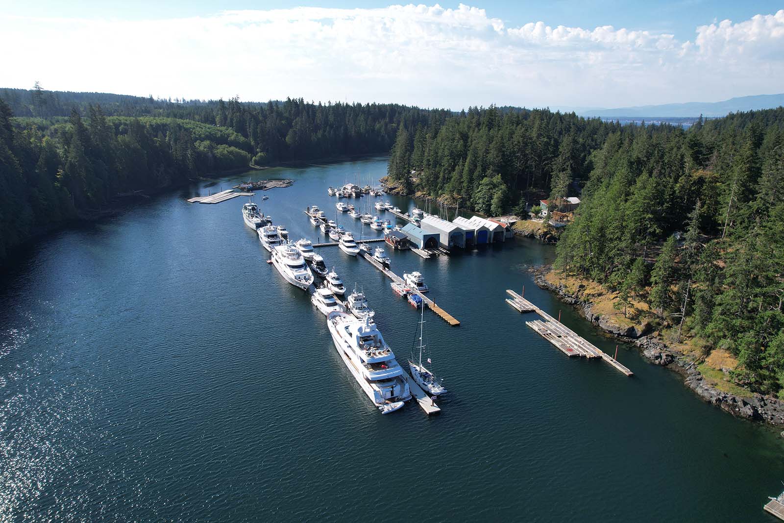 Landscape photo of marina dock with boats docked and sunrise and purplish skies and crisp ocean